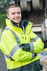 happy young working man standing near dustbin on street