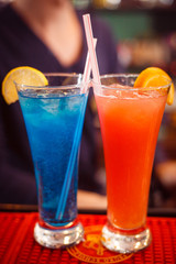 Two alcoholic cocktails that makes a barman
