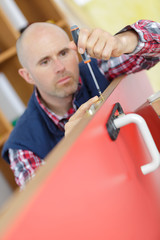 portrait young male carpenter repairing door lock
