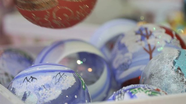 Close-up of New Year theme man's hand taking glass bowl with patten and slowly rotate it