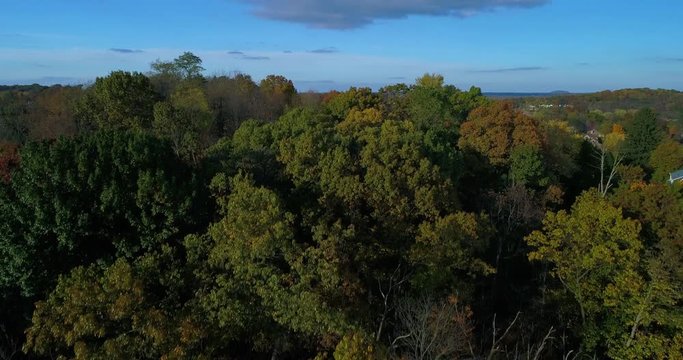A rising aerial establishing shot revealing the landscape of a typical Western Pennsylvania valley and residential neighborhood in Autumn. Shot at 48fps.
