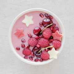 red pink smoothie bowl with cherry, strawberry, raspberries and pomegranate