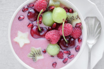 red pink and green smoothie bowl with cherry, melon, strawberry, raspberries and pomegranate , christmas fun food