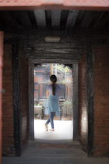 girl standing outside the door of an ancient building