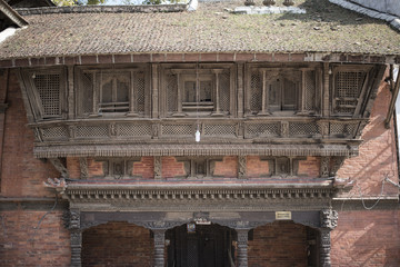 bulb hanging outside of an old building with wooden windows
