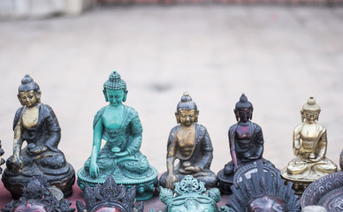 Different colours Buddha statue in a row