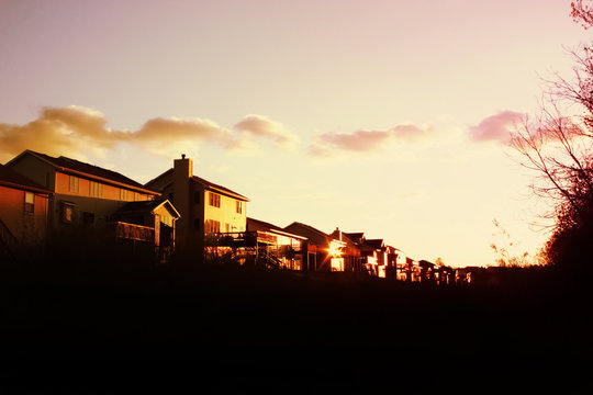 Evening sun setting on a row of suburban houses in a subdivision