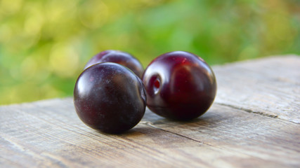 Plums on a wooden table in the garden