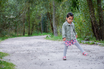 Little latin girl walking in the forest.