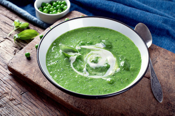 Green pea soup on wooden cutting board. Top view