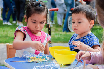 Little latin girl and boy making crafts.
