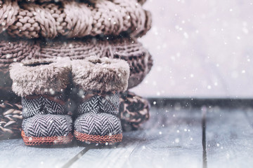 Stack Pile of cozy knitted sweaters on a wooden table. Warm concept. Snow, toning image
