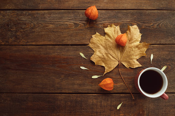 Naklejka na ściany i meble autumn coffee or tea warm maple leaf wooden surface background concept. Seasonal coziness. Disease prevention