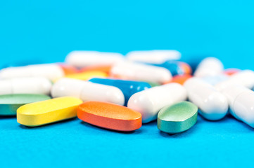 Different pills on a blue background. Medical background.