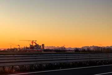 sun goes down behind an industry