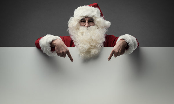 Santa Claus pointing at blank sign