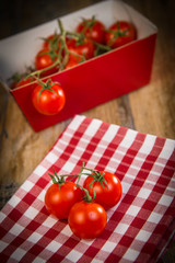 Fresh cherry tomatoes on travel and wooden background