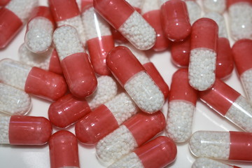 Fototapeta na wymiar lot of white red capsule pills on white background