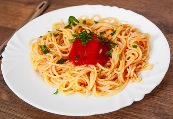 Pasta spaghetti with tomato sauce on white plate. on a wooden background.