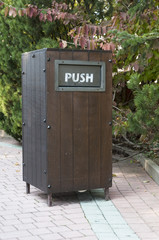 wooden trash can with push in the park