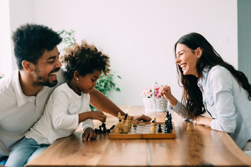 Fototapeta premium Happy family playing chess together at home