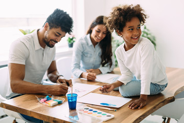 Mother and father drawing together with their child