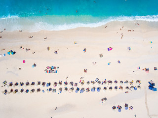 People bathing in the sun, swimming and playing games on the beach. Tourists on the sand beach in Kefalonia island, Greece