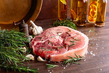 Raw pork with rosemary , salt and pepper.