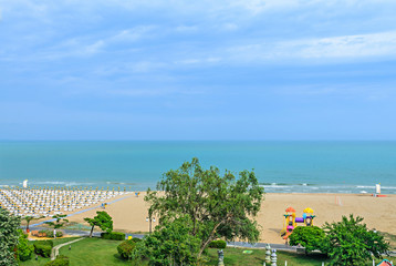 Beach of Black Sea from Albena, Bulgaria with golden sands, blue clear  water, green trees