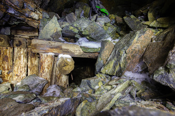 Fototapeta premium Abandoned old chromite mine shaft tunnel with wooden timbering