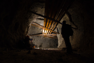 Fototapeta premium Underground mine shaft iron ore tunnel gallery with miner and pipes