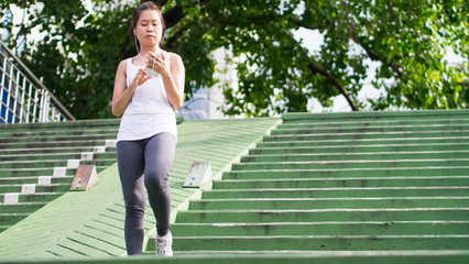Obraz premium sport woman using mobile phone running in city urban building overcrossing background