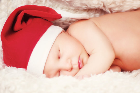 A baby in a Santa Claus hat