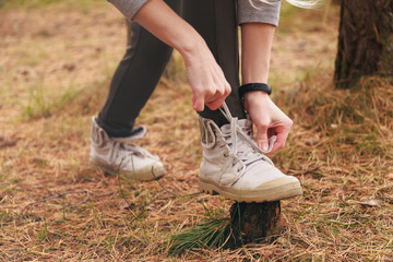 Hiking shoes - woman tying shoe laces. Closeup of female tourist getting ready for hiking