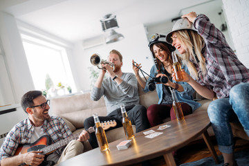 Happy group of friends playing instruments and partying