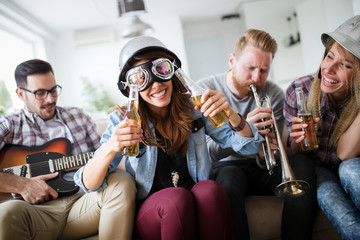 Group of friends playing guitar and partying at home
