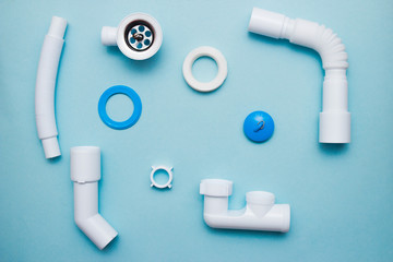 White plastic fittings for plumbing on a blue background