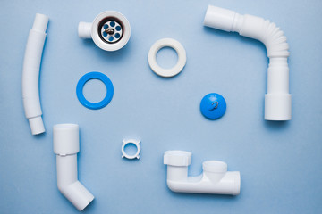 White plastic fittings for plumbing on a blue background