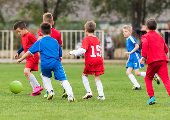 Naklejka premium Young children players football match on soccer field