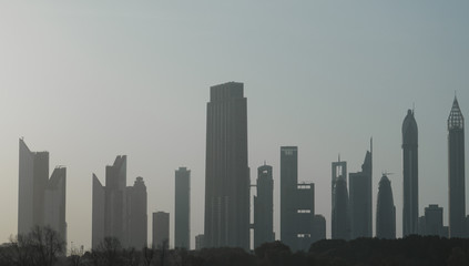 Fototapeta premium Architectural background with silhouettes of tall buildings. Dubai. In the summer of 2016. 