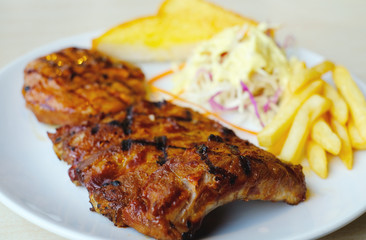 closeup barbecue pork rib serve with salad, frenchfries and butter bread