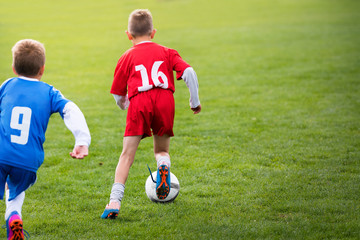 Obraz premium Young children players football match on soccer field