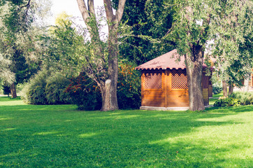 Wooden gazebo in park surrounded by trees