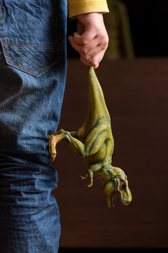 Hand Holding Green Dinosaur Toy Figure