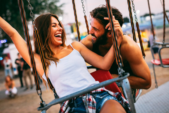 Young couple enjoying on the swings