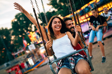 Young couple enjoying on the swings