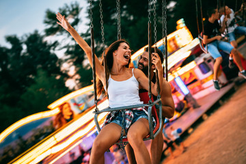 Young couple enjoying on the swings