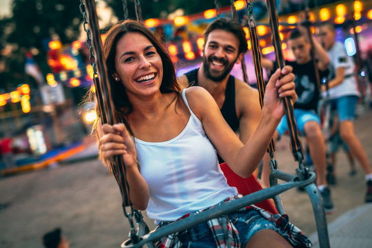 Young couple enjoying on the swings