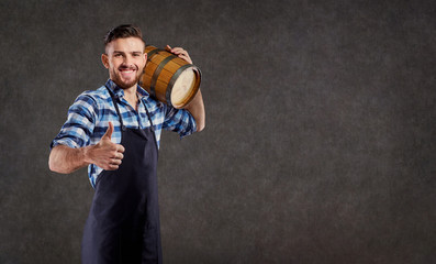 A brewer with a barrel in his hand against the background of copyspase.