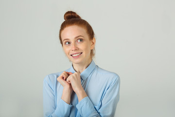 beautiful young smiling girl with red hair on a light background